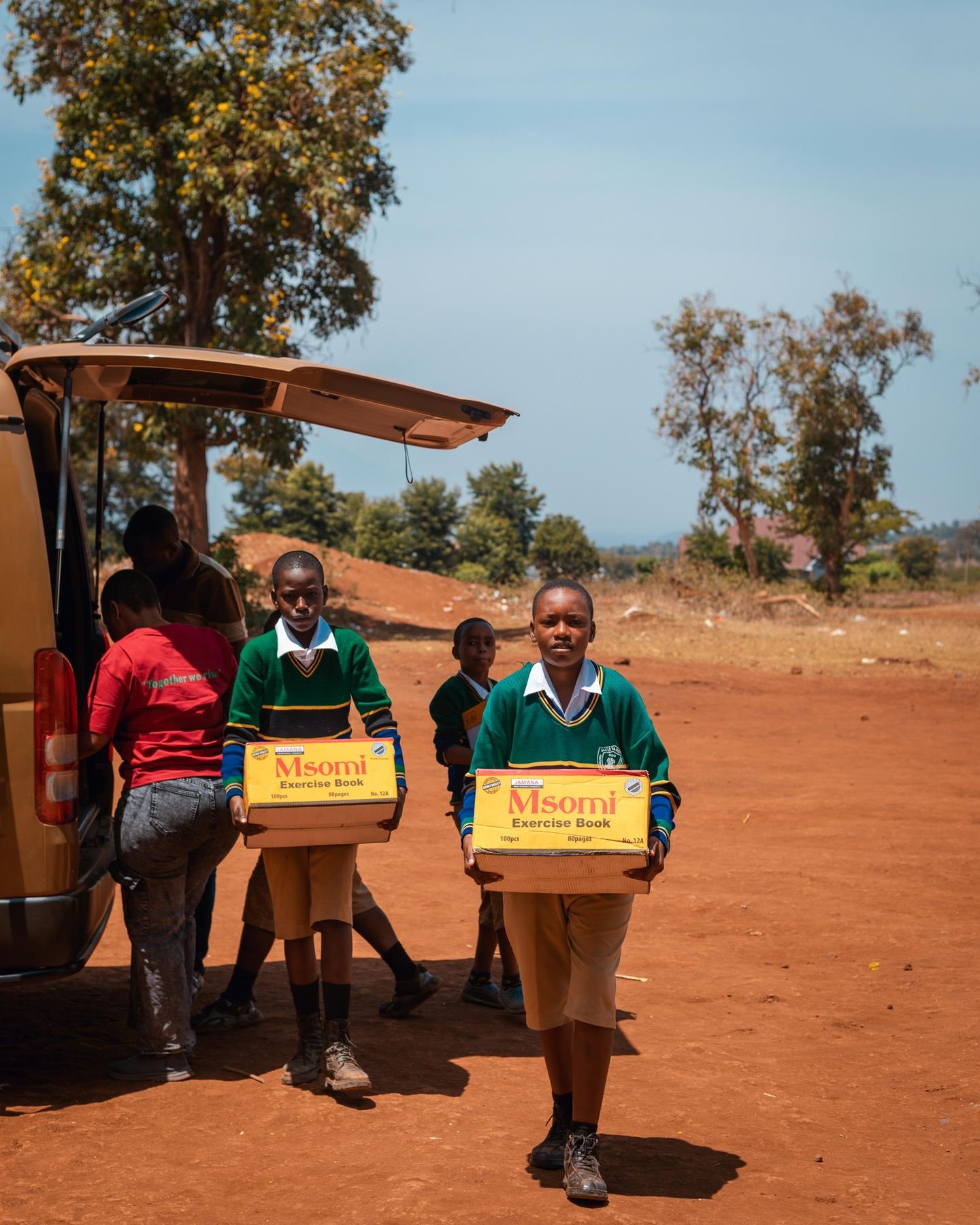 Pupils carrying boxes of school supplies