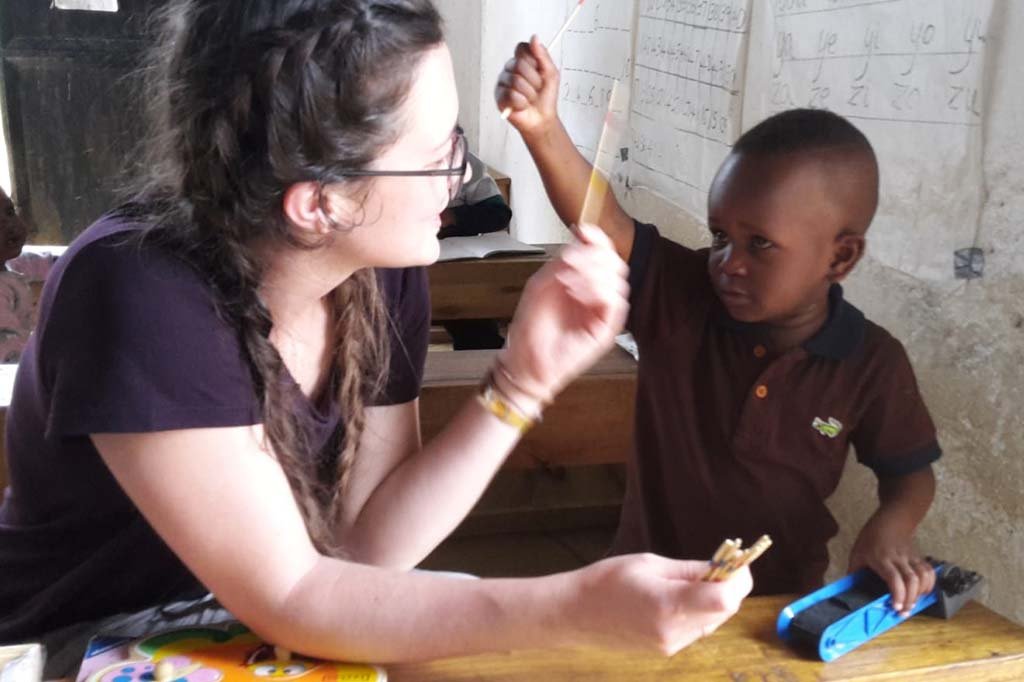 Volunteer working with a child in class